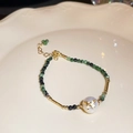 Bracelet perles baroques avec perles facettées vert foncé et nœud doré - Style Papillon aux Perles Vertes