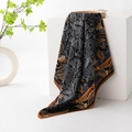 Elegant black silk scarf featuring orange paisley patterns draped on a white block - Black Paisley