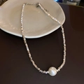 Detailed view of silver metal chain necklace with a large pearl pendant on a plate - Silver Metal Chain Single Pearl Necklace