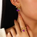 Golden bow jewelry set featuring purple beads and green leaves on earrings and ring - Purple Bead Earrings & Ring Set