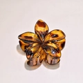 Detail of a resin plumeria flower hair claw clip with amber leopard tortoiseshell pattern - Yellow Leopard Print 8cm