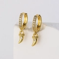 Exquisite 18K vergoldete Creolen mit Zirkon-Hornanhängern auf einem weißen Naturstein - Gold