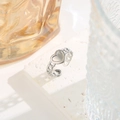 Detailed macro shot of silver heart ring with chain band design on a white stone base - Chain Heart Silver