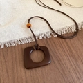 Détail du collier avec pendentif carré en résine marron et perle ambrée sur bois - 25# Collier-Café