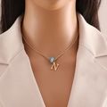 Detail view of gold twisted chain with letter N pendant and blue evil eye charm on model - Letter N (N1339)