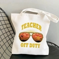 White canvas tote bag featuring yellow Teacher Off Duty print with sunset sunglasses graphic - Yellow Teacher Off Duty