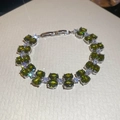 Detailed macro view of olive green oval zircon stones and silver clasp on the bracelet - Green