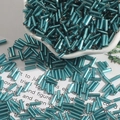 DIY 2x7mm blue-green silver-lined glass bugle beads scattered on decorative paper - Diameter approx 2mm x Length approx 7mm 15g/Pack Approx 300 Pieces / Peacock Blue