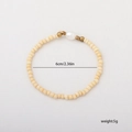 Elegante bracciale con perline crema, distanziatori dorati e una perla bianca - 1 Pezzo / Beige