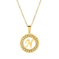 Detail of a gold circular necklace pendant with letter N and sparkling zircon inlay - Letter N