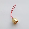 Close-up of a 2cm golden metal Christmas bell with a red braided cord for DIY crafts - 2cm Gold Bell (Red Rope)