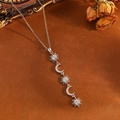 Detail of silver necklace featuring sun and moon pendants with sparkling crystals - Silver Sun Moon Tassel Necklace