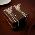 Pendientes de mariposa con perlas y borlas largas sobre una caja de joyería de lujo - Poste de pendiente de plata - Rosa