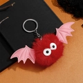 Détail d'un porte-clés chauve-souris en peluche rouge avec ailes et yeux mignons - Rouge