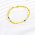 Close-up of bohemian stacked bracelet with vibrant yellow, blue, and gold beads - Yellow Blue Mixed