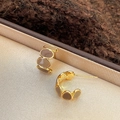 Close-up of golden C-shaped hoop earrings with brown enamel on beige jewelry padding - Gold & Coffee C-Shape (Silver Earring Post)