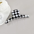 Detail view of checkerboard hair claw clip with 8 teeth on a minimalist grey background - Black/White Hanger Clip