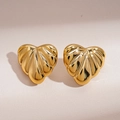 Macro detail of gold-plated heart earrings with textured rippled finish on a beige backdrop - Gold (925 Sterling Silver Earring Post)