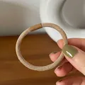 Close-up of a khaki twill elastic hair tie with a durable matching connector piece - Apricot