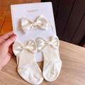 Detail of infant headband and socks set featuring cream satin bows and ribbed knit texture - (Creamy Yellow) Ribbon Bow Set
