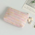 Pink tweed coin purse with decorative bow and pearl tassel on a clean background - Pink