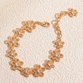 Detalle de pulsera vintage dorada con flores de circón y pétalos calados - Dorado