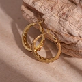 Gedetailleerd macro-aanzicht van gouden geometrische oorbellen met amber strassteentjes - Gouden Creole (925 Zilveren Pin)