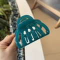 Detail of dark teal pumpkin-shaped hair claw clip with large teeth and gold spring - Cyan Blue