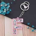 Letter F keychain in pink transparent acrylic with colorful star sequins and silver clip - Letter F
