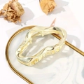 Eleganter goldener Metall Haarklammer in Wolkenform mit welligem Design auf Marmortablett - Gold