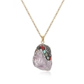 Detailed close-up of light purple crystal pendant with colorful rhinestones on gold chain - Purple