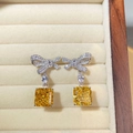 Dettaglio ravvicinato di orecchini a fiocco in argento con pietre di zircone giallo - Giallo