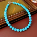Dettaglio di una collana minimalista di perline turchesi con chiusura in argento su cornice - Diametro della perla 10mm