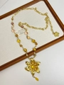 Detail of vintage gold flower pendant necklace with amber beads and pearl accents - Gold Lily Flower Colored Beads