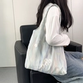 Borsa tote blu con texture acquerello e ricami floreali portata a spalla da modella - Stile Gilet / Ricamo Blu Pittura a Inchiostro