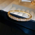 Elegante bracciale a quadrifoglio dorato con zirconi brillanti in una scatola - Oro