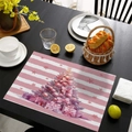 Detail of pink Christmas placemat with festive tree and gifts on a black table - CD57-16
