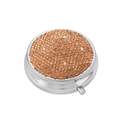 Detail of round silver pill box with sparkling orange rhinestones and push-button release - Peach