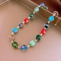 Gros plan du collier vintage en perles de verre colorées sur un plateau rose doré - Collier-Multicolore