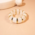 Dettaglio del bracciale elastico segmentato in resina marmorizzata bianca e metallo oro - Bianco