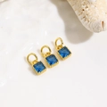 Macro shot of three geometric square blue zircon pendants with 18k gold plated brass finish - Light Blue