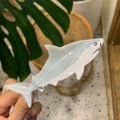 Close-up of a blue and white acetate great white shark hair claw clip held in hand - Light Gray Shark White Eye