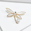 Détail d'une broche libellule avec ailes dorées, perles et cristaux étincelants - Broche Libellule en Cristal Blanc