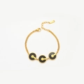 Dettaglio di ciondoli circolari oro e neri su bracciale in acciaio con targhetta S.steel - Bracciale / Bracciale a Cerchio Oro Nero