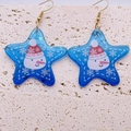 Blue star-shaped acrylic snowman earrings with festive snowflakes and gold metal hooks - Blue Star Snowman