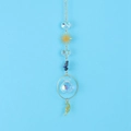 Close-up of golden sun and crescent moon suncatcher with crystal prisms and blue stones - Blue Sodalite