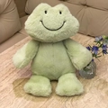 Soft plush green frog toy with embroidered smile sitting on a marble table surface - Smiling Frog / 35cm
