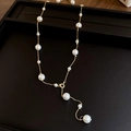 Vue détaillée du collier élégant en Y doré avec perles artificielles sur plateau - Collier - Or