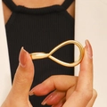 Anello aperto geometrico dorato minimalista con finitura lucida sulla mano di un modello - Stile Infinito Oro (KC Oro Z-627)