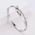 Close-up of a silver butterfly bangle with matte finish and sparkling cubic zirconia stones - Steel